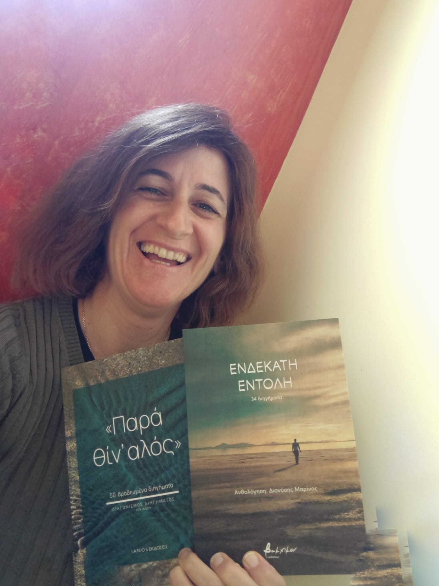 Η Χριστίνα Αντωνιάδου κρατά δύο από τα βιβλία της με τα διηγήματά της, «Ενδέκατη Εντολή» και «Παρ' αθίν αλός»